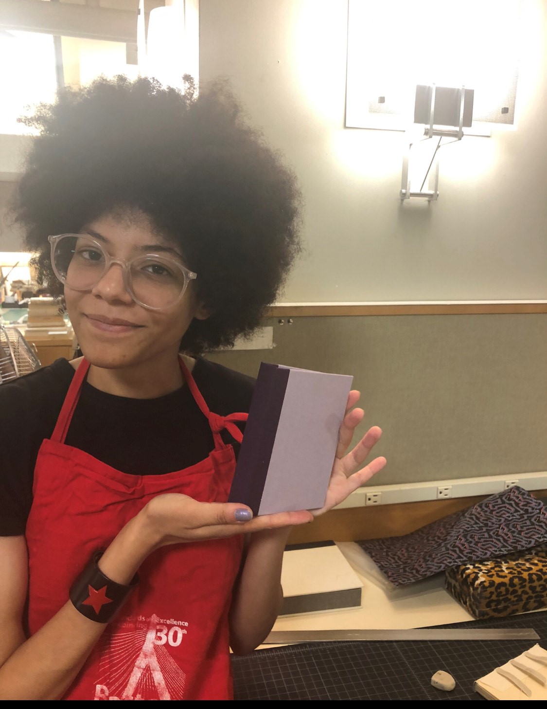 Person proudly displaying a bound pamphlet they have just made
