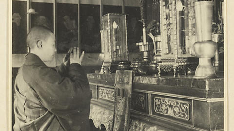 Buddhist Nun Kneeling at Altar