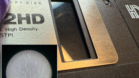 Photo of mold on a disk, with an inset image of what that mold looks like zoomed in with a pocket microscope, where viewers can see the webby-looking hyphae.