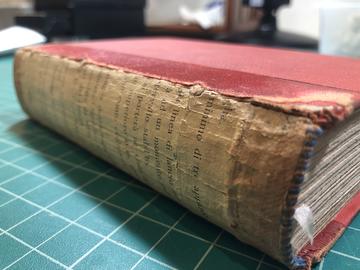 a book with a spine lining of waste paper from another book.