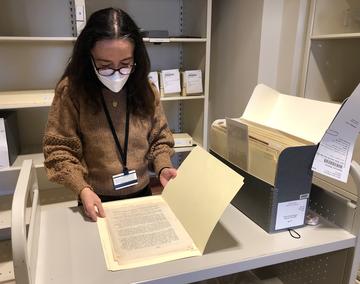 A woman reviewing a paper document.