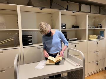 A woman reviewing a book.