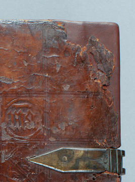 The repaired wooden board corner covered in dyed leather.