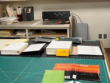 A work bench full of books in progress.