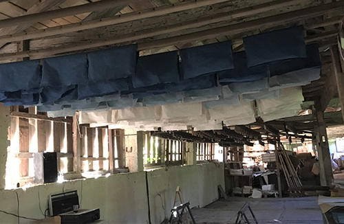 Handmade blue and white papers hanging from ceiling of drying loft