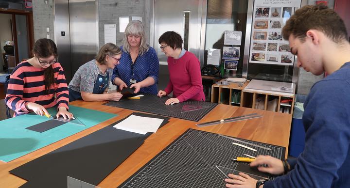 Students and staff making book cradles
