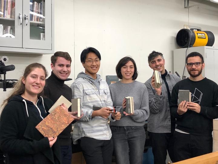Students holding the books that they made in the workshop.