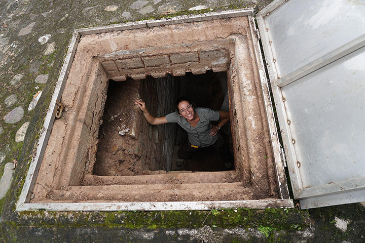A woman looking up from an underground entrance.