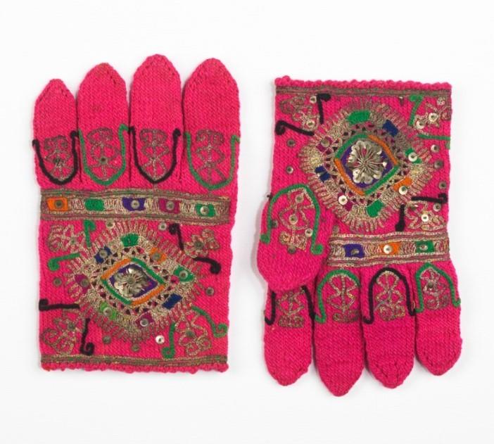 A pair of decorated pink costume gloves.